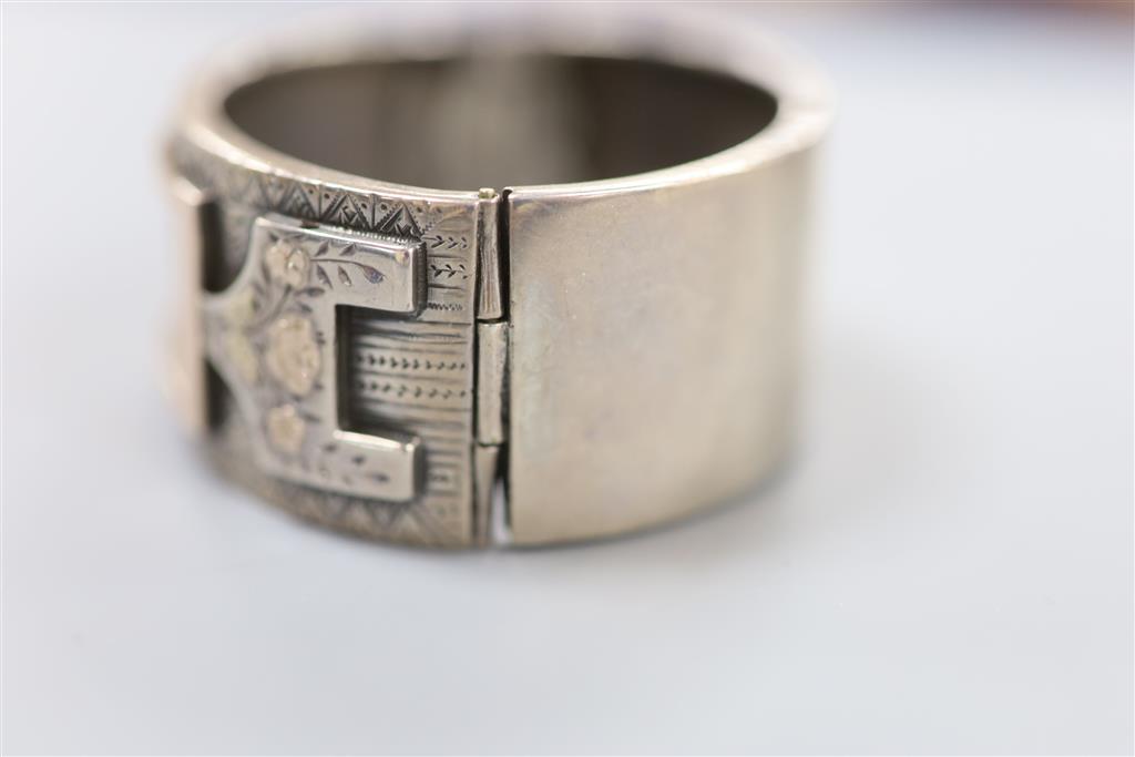 A late 19th century white and two colour yellow metal overlaid hinged bangle, gross 35.4 grams,